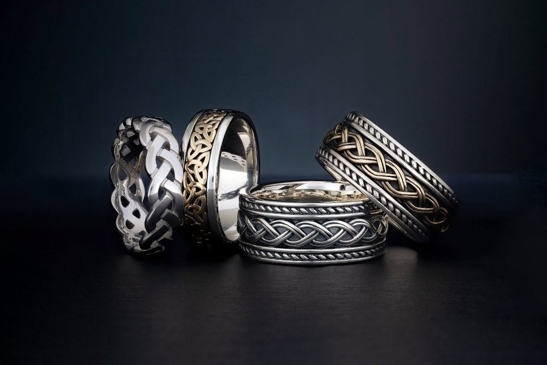 a set of men's celtic rings on a dark background