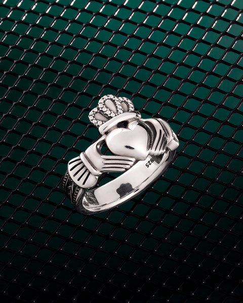 mens claddagh ring presented on styled background