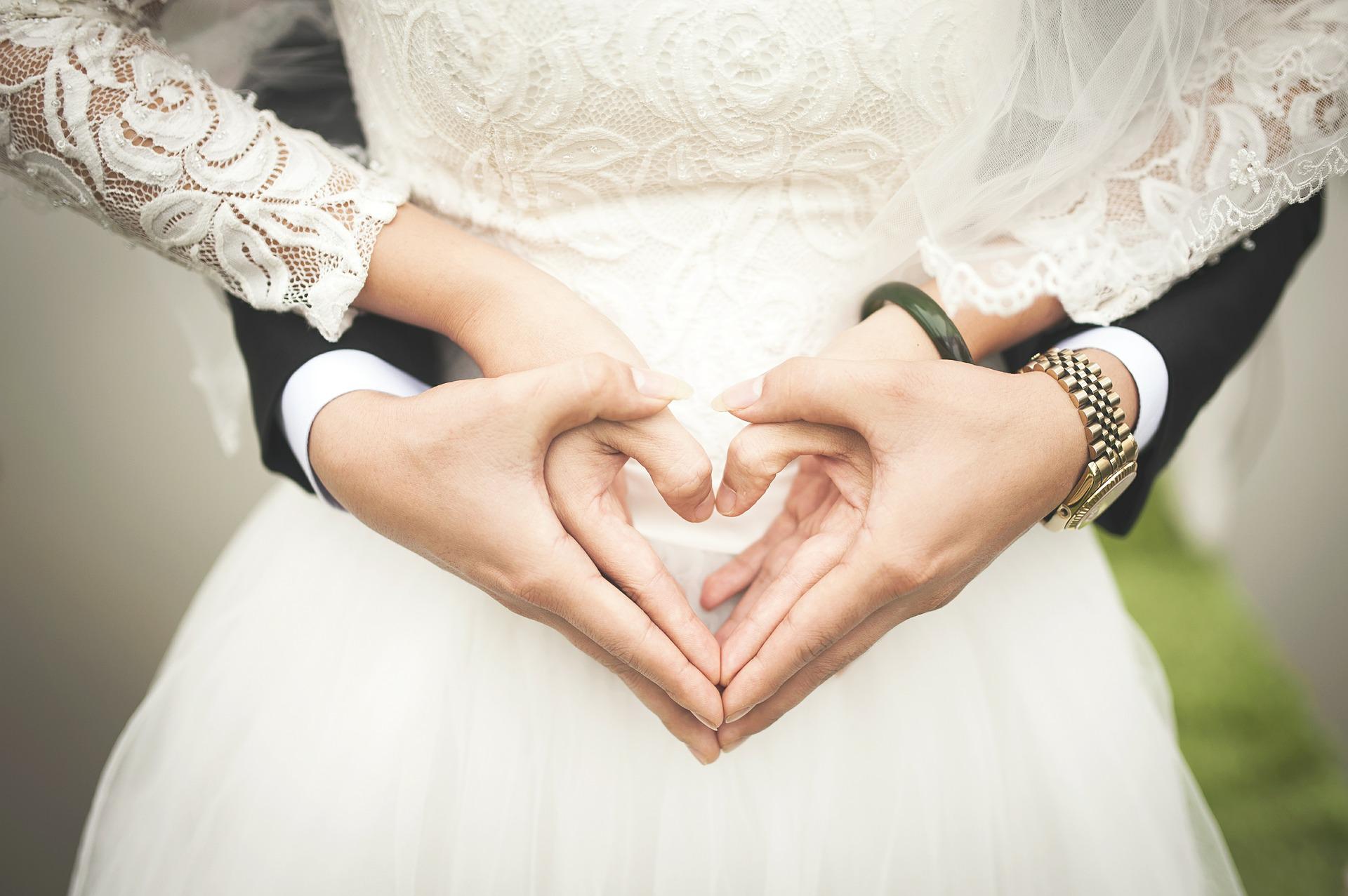 a bride couple is holding their hands together