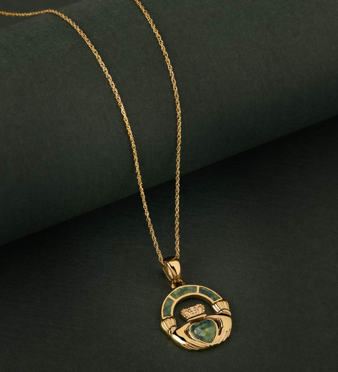 Connemara Marble gold Claddagh necklace on green background