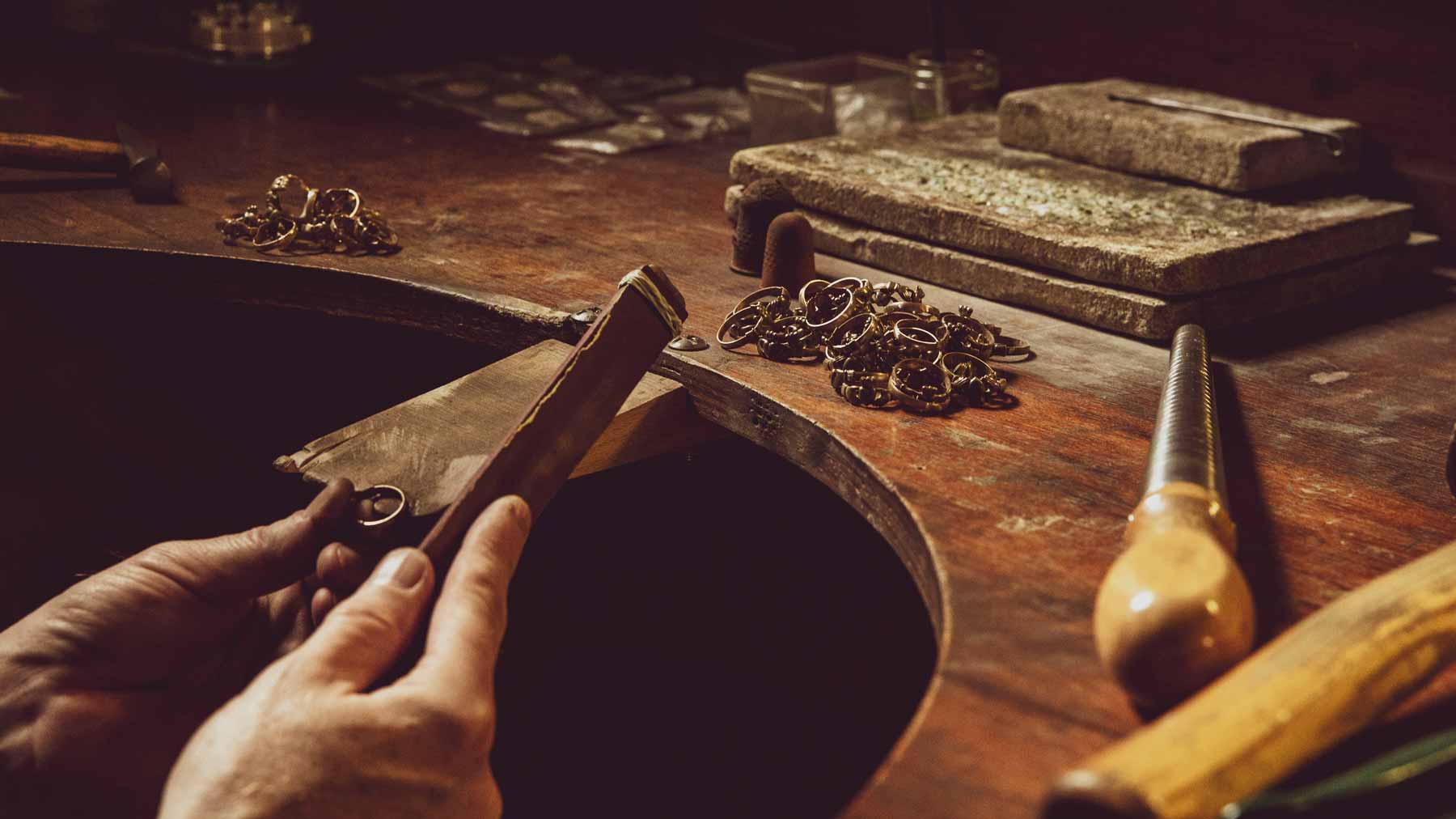 goldsmith crafting the rings at his workspace