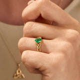 closeup image of yellow gold emerald Celtic Knot Ring on a model