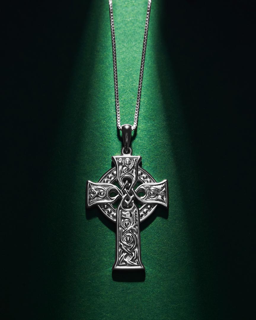 styled image of small four apostles celtic cross pendant s46604 on green background