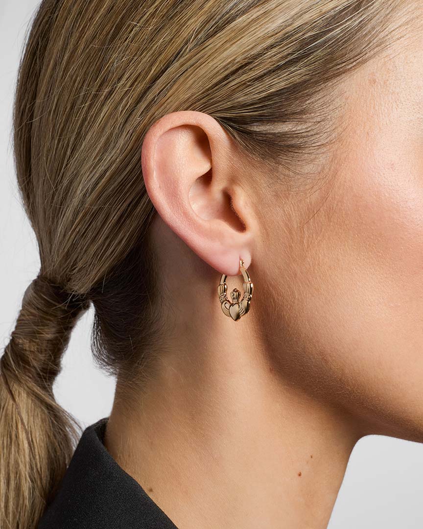 model wearing yellow gold Claddagh hoop earrings from Solvar