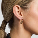 model wearing yellow gold Claddagh hoop earrings from Solvar