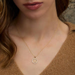 a model wearing yellow gold round trinity knot necklace from Solvar