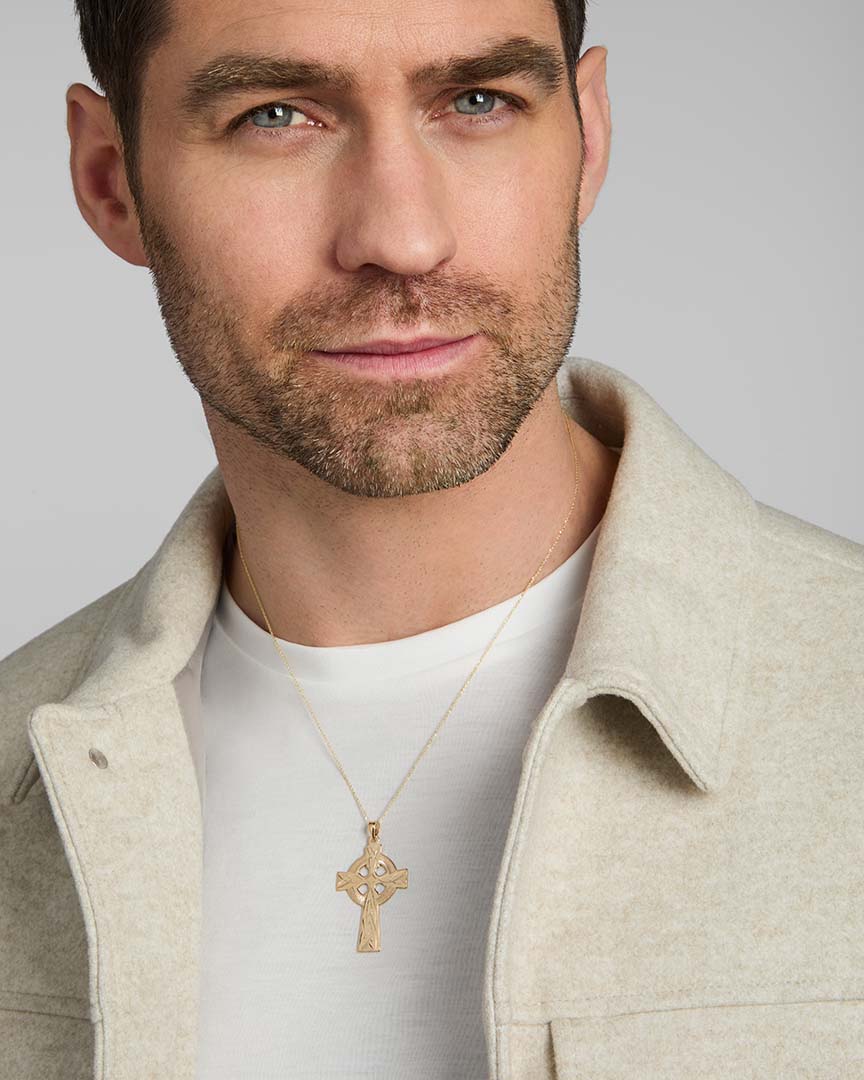 a male model wearing hand engraved yellow gold heavy Celtic cross from Solvar