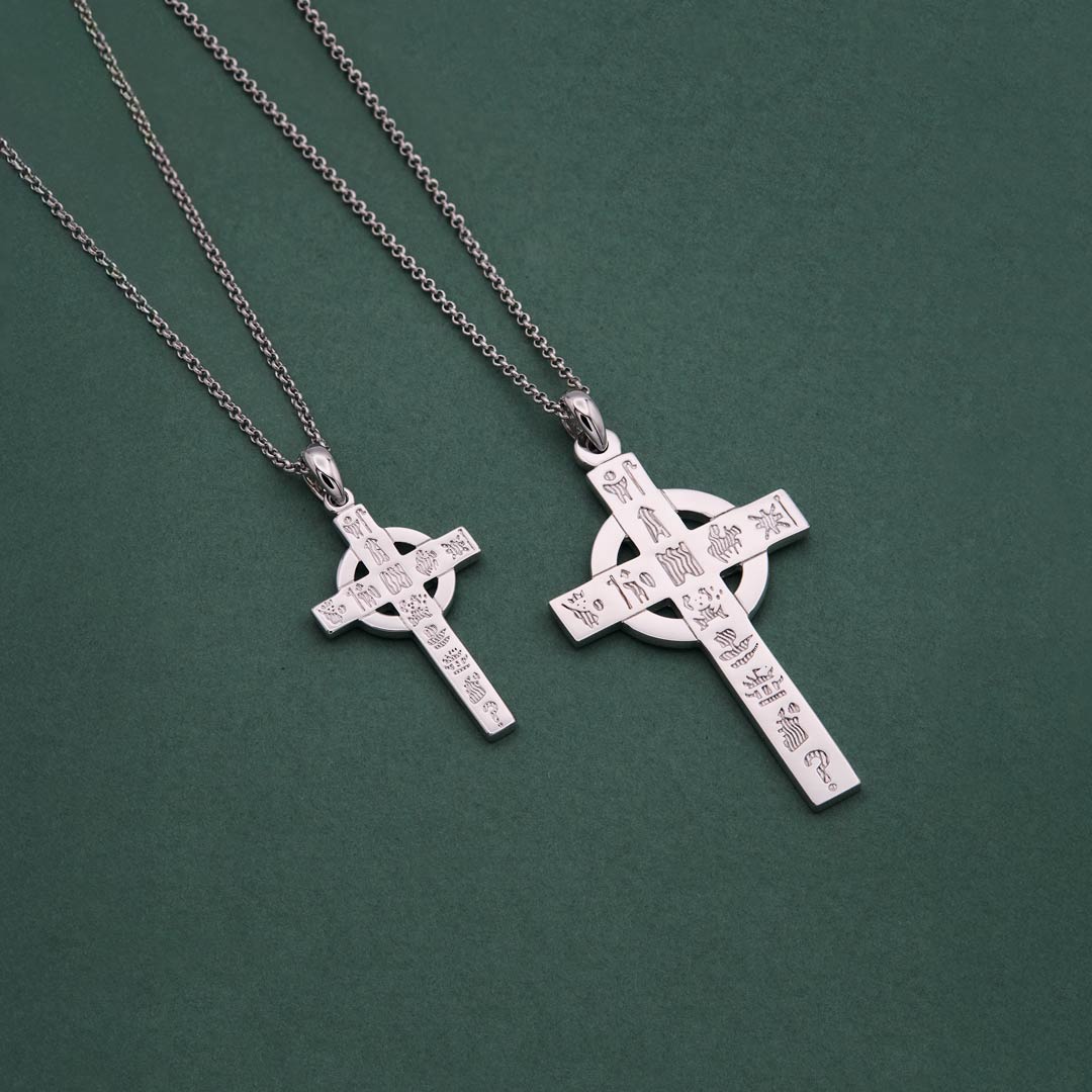 light and heavy History of Ireland cross necklaces on a green background
