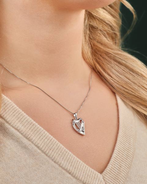 silver harp necklace presented on a model