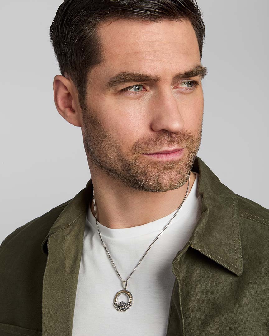 male model wearing gold and silver Celtic Claddagh pendant from Solvar
