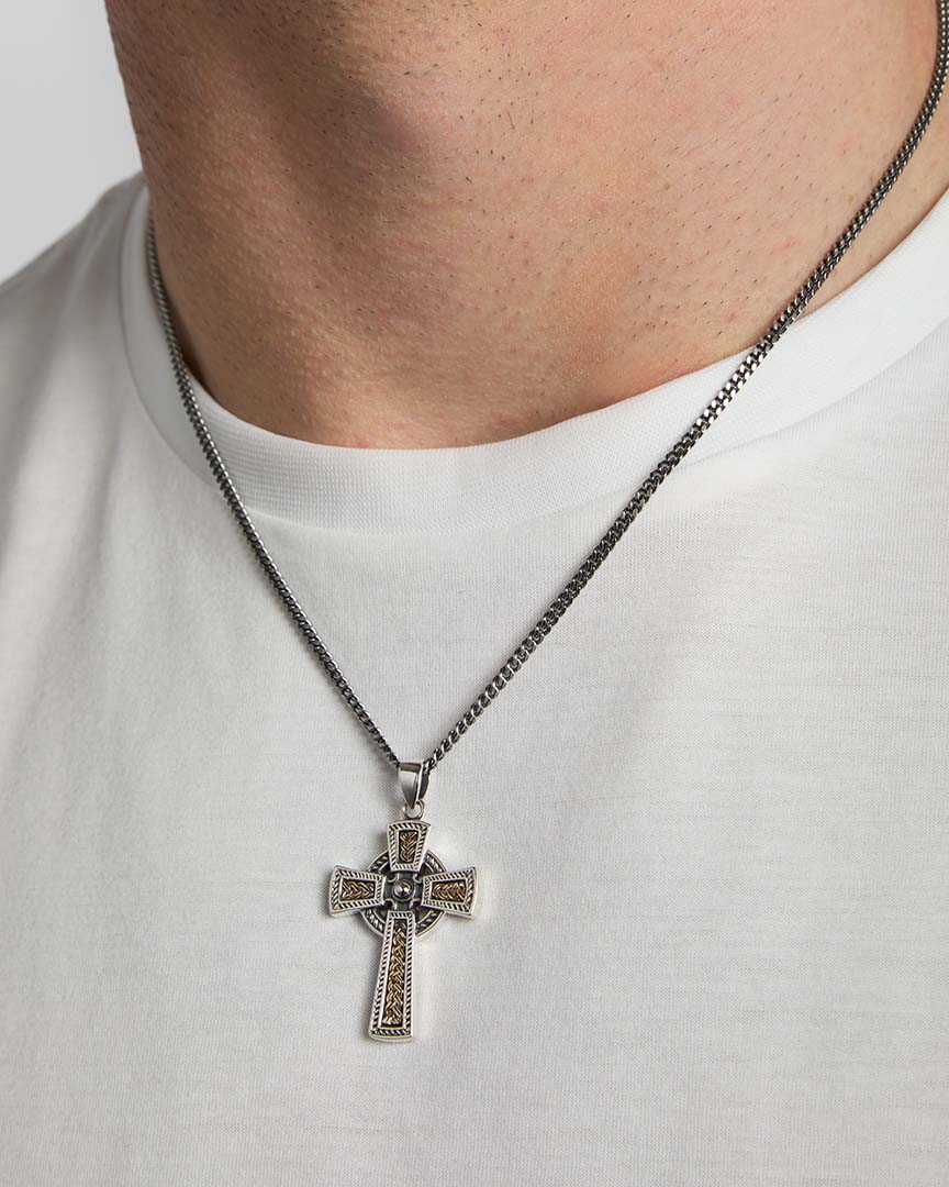 closeup image of gold and silver Celtic Cross pendant on a male model