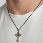 closeup image of gold and silver Celtic Cross pendant on a male model