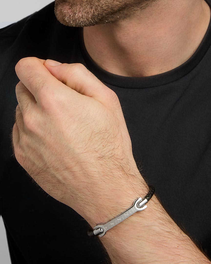 closeup image of men's stainless steel Celtic black leather bracelet on a model