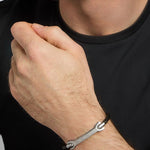 closeup image of men's stainless steel Celtic black leather bracelet on a model