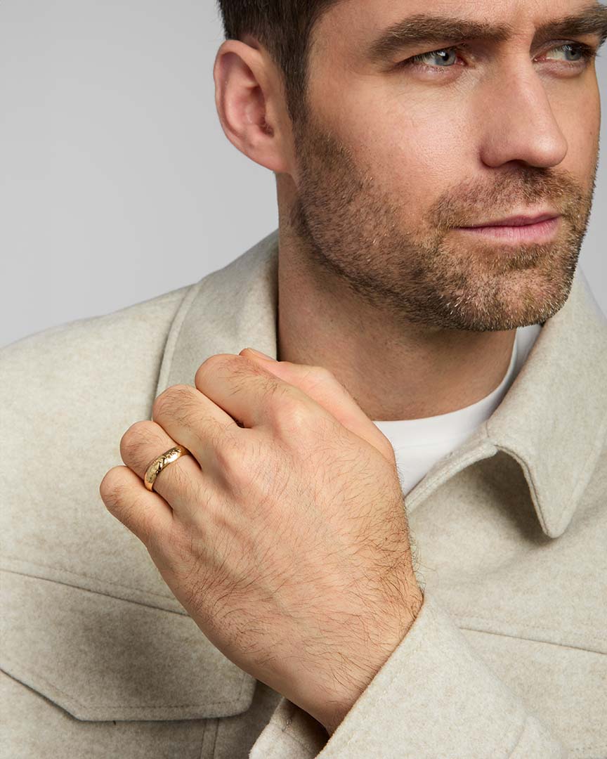 a male model wearing gold claddagh wedding band ring