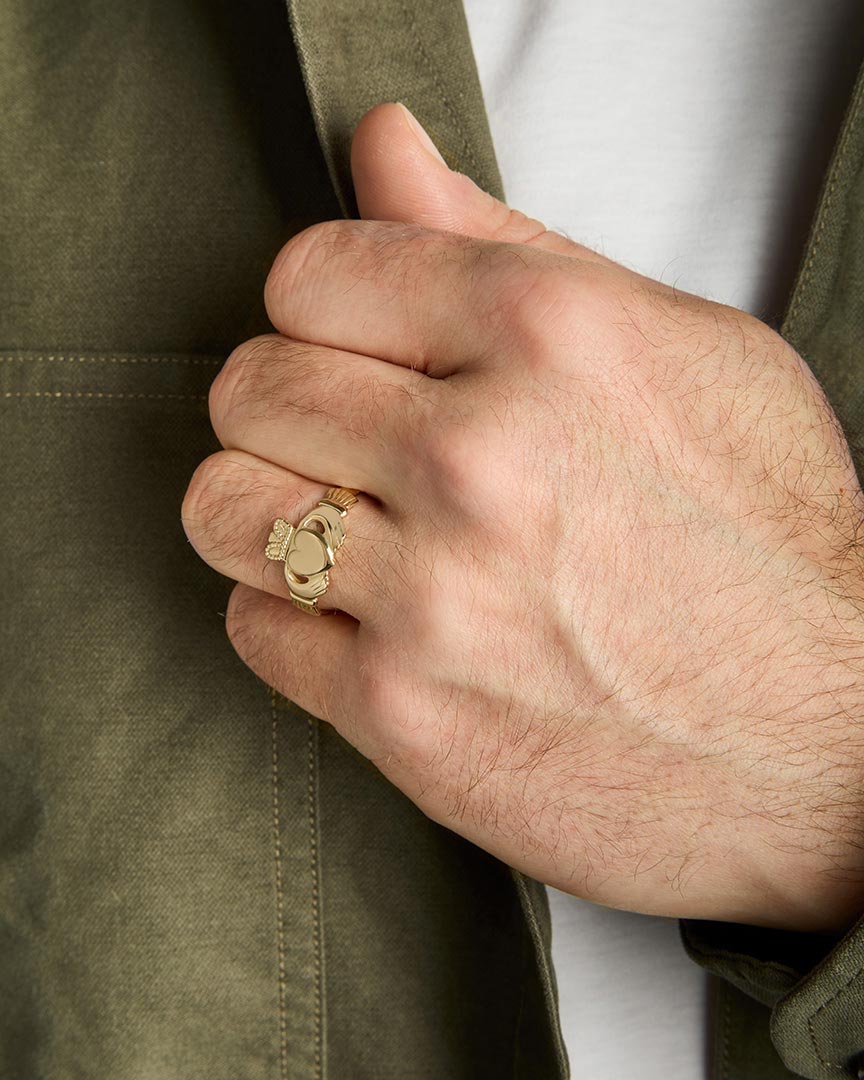 traditional men's gold Claddagh ring on a model