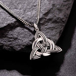 lifestyle image of mens heavy celtic knot pendant on dark background