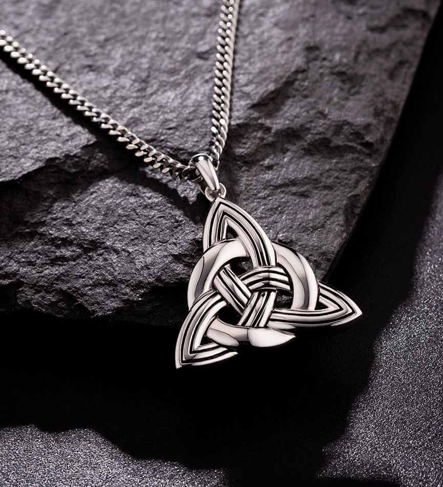 lifestyle image of mens heavy celtic knot pendant on dark background