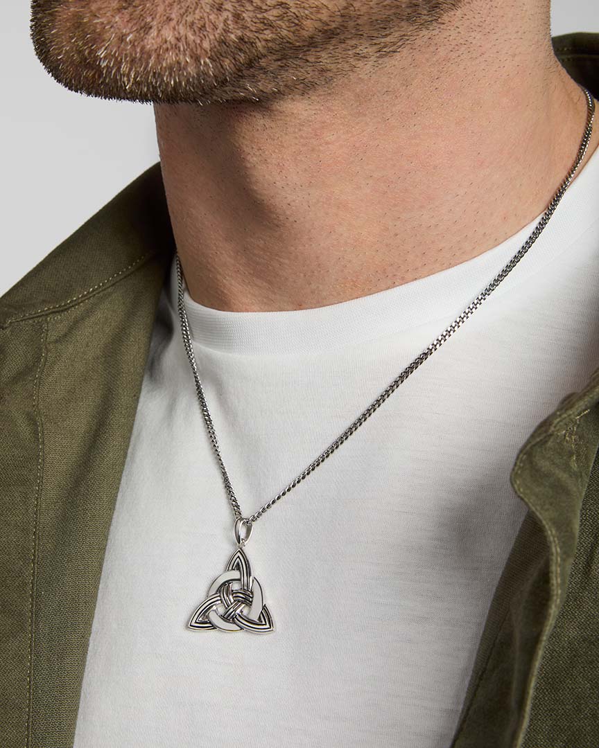 closeup image of men's large Celtic Knot pendant in silver on a model