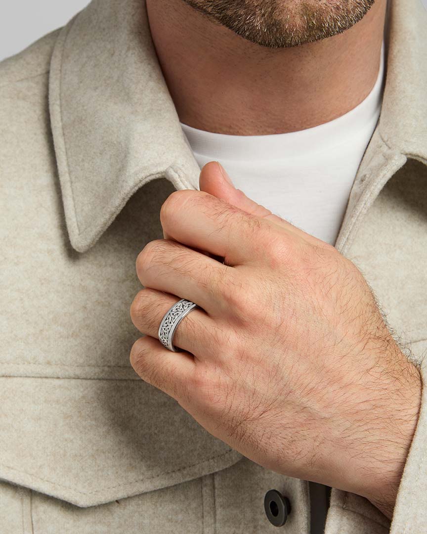 closeup image of oxidised silver men's Trinity Knot band ring on a model
