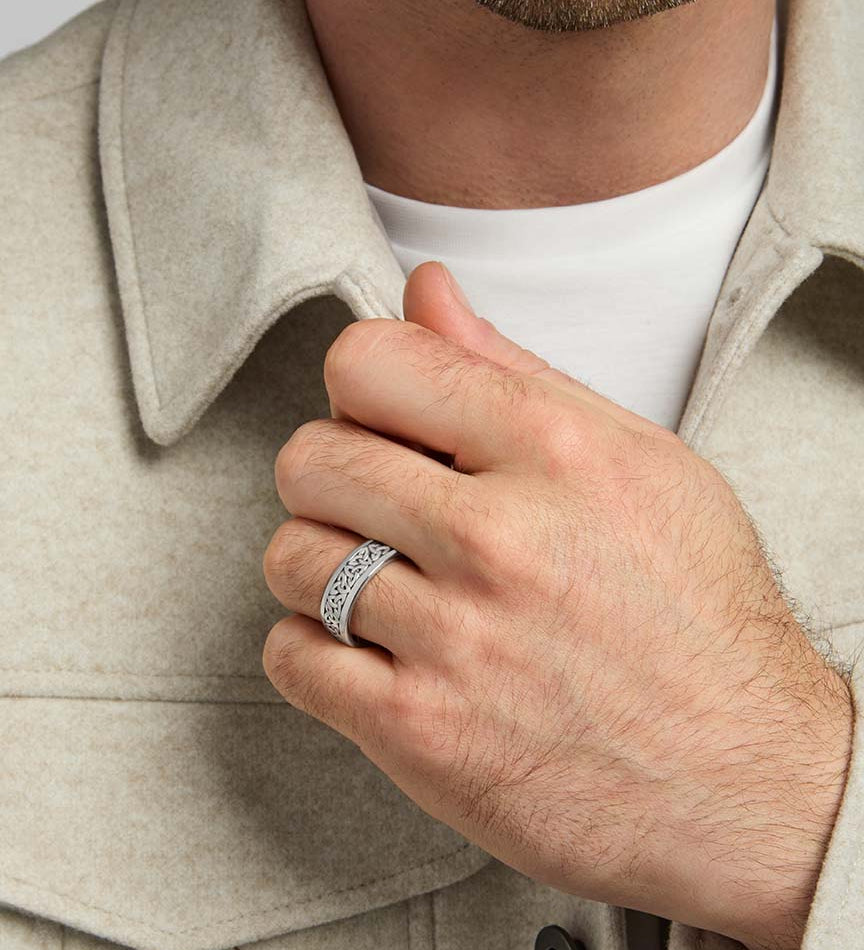 closeup image of oxidised silver men's Trinity Knot band ring on a model