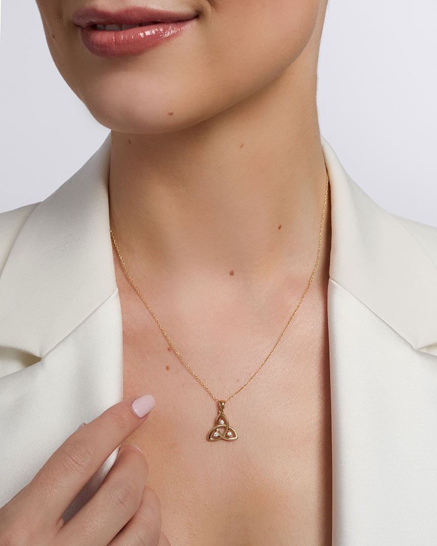open cz gold trinity knot pendant on a model 1