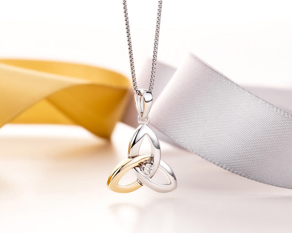 gold and silver celtic necklace on a styled background