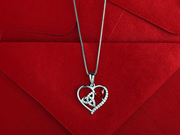 Red Cz heart Trinity Knot pendant styled on the red background