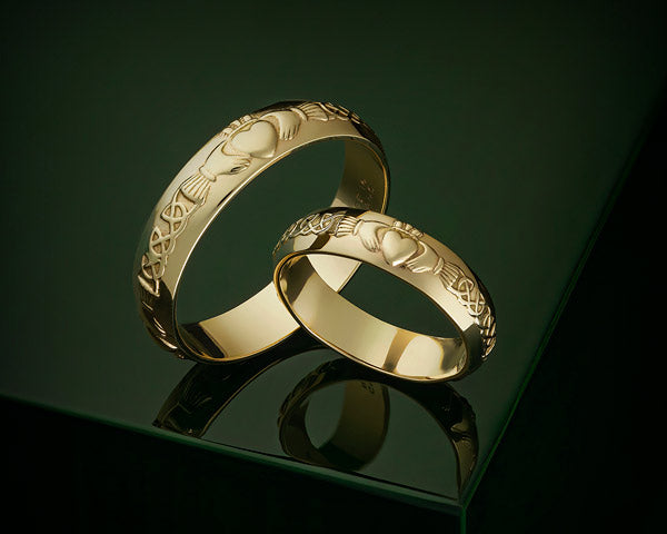 gold claddagh wedding bands on a styled background