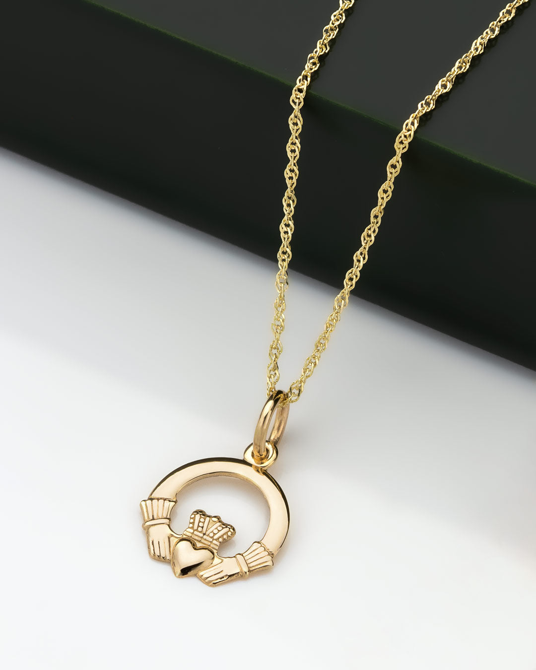 lifestyle image of small gold Claddagh pendant