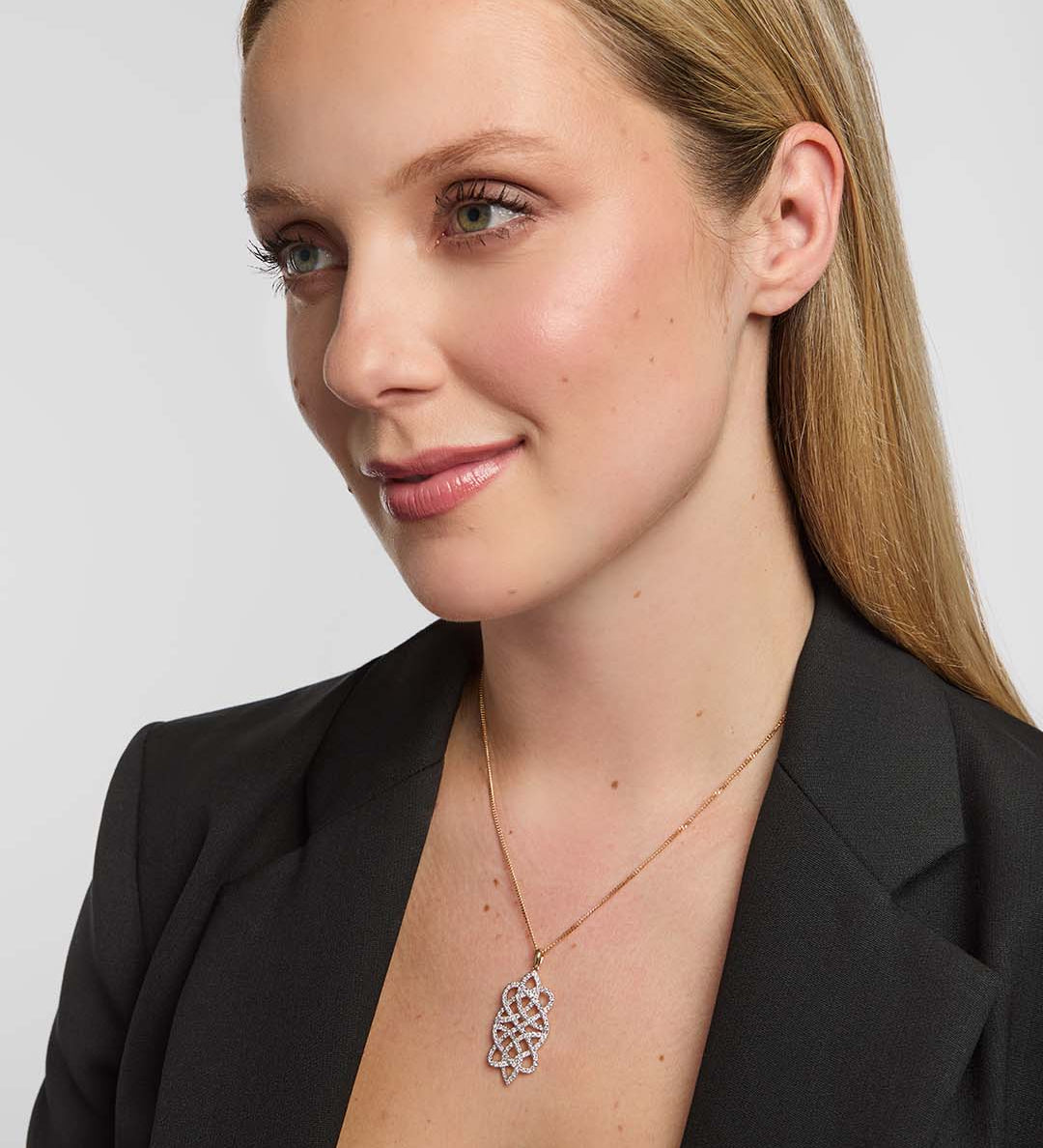 Female model wearing a luxurious Solvar Celtic knot necklace featuring shimmering diamonds