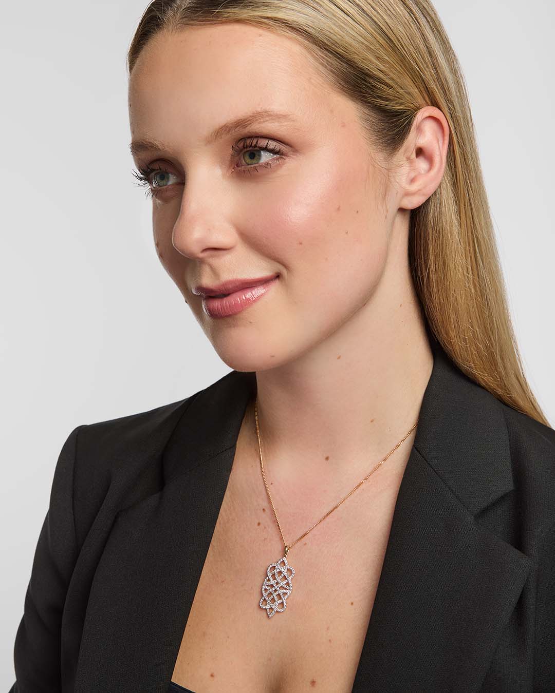 Female model wearing a luxurious Solvar Celtic knot necklace featuring shimmering diamonds