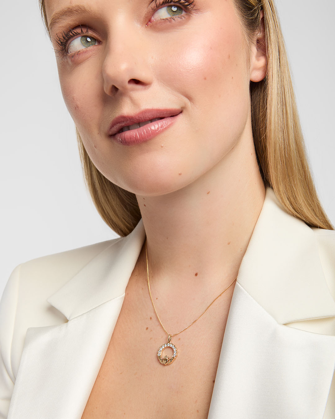 Female model wearing an elegant 14K gold Claddagh necklace accented with brilliant diamonds