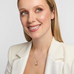 Female model wearing a radiant 14K gold Claddagh pendant with a shimmering diamond halo