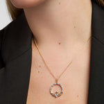 Close-up of a model showcasing a Solvar gold Claddagh necklace with a striking, large diamond set in the heart pendant.