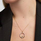 Close-up of a model showcasing a Solvar gold Claddagh necklace with a striking, large diamond set in the heart pendant.