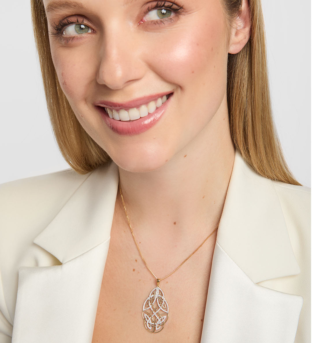 close up image of large diamond celtic knot pendant displayed on a female model