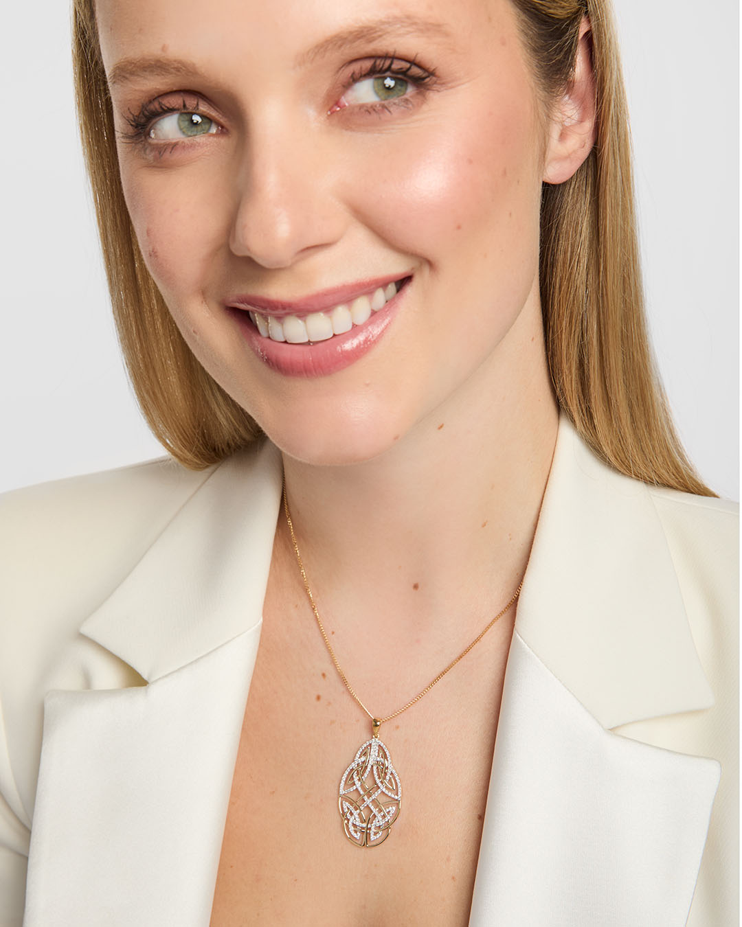close up image of large diamond celtic knot pendant displayed on a female model