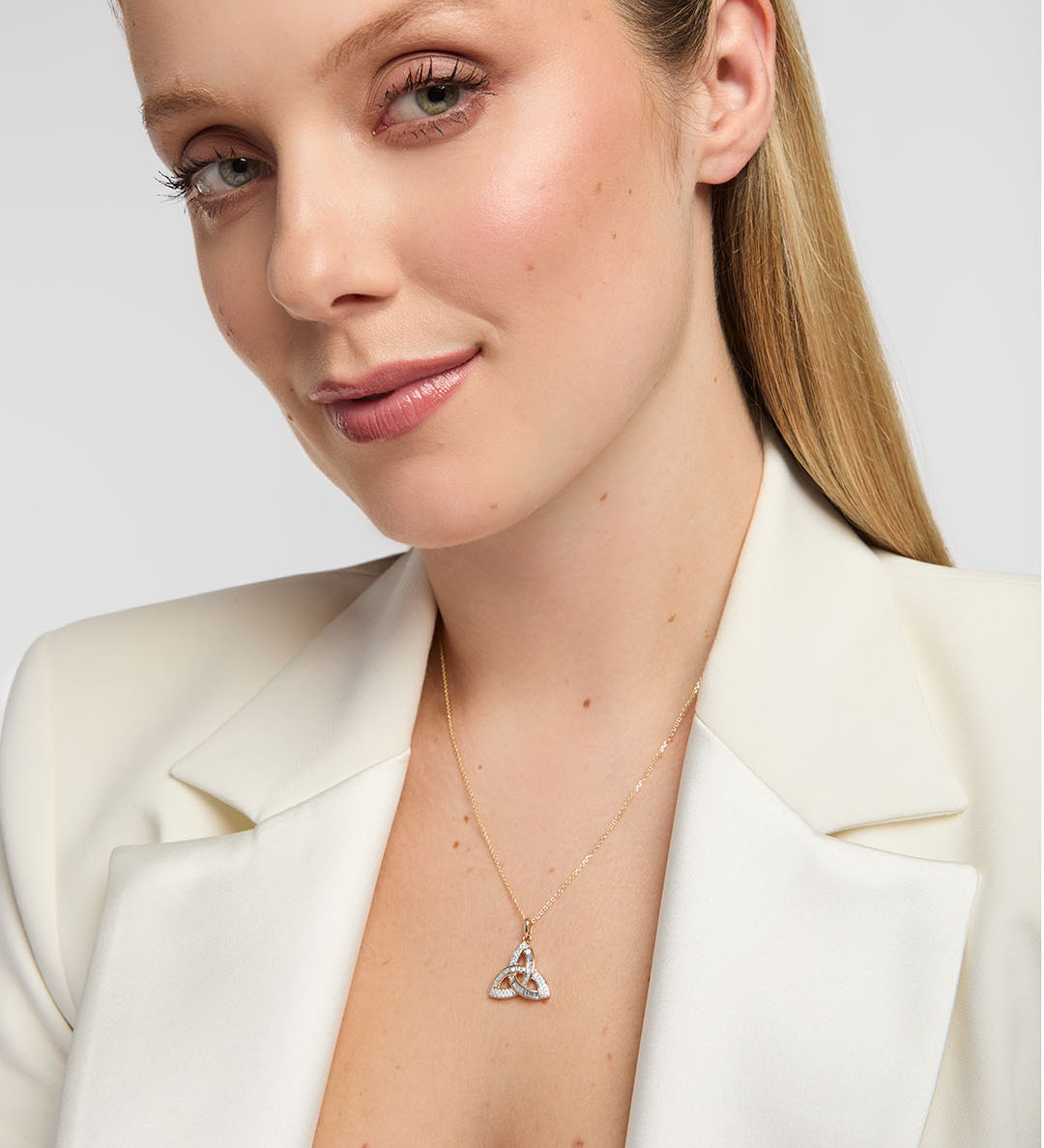 model wearing 14K gold Trinity Knot pendant with sparkling diamonds, symbolising eternal love and Irish heritage in an elegant design