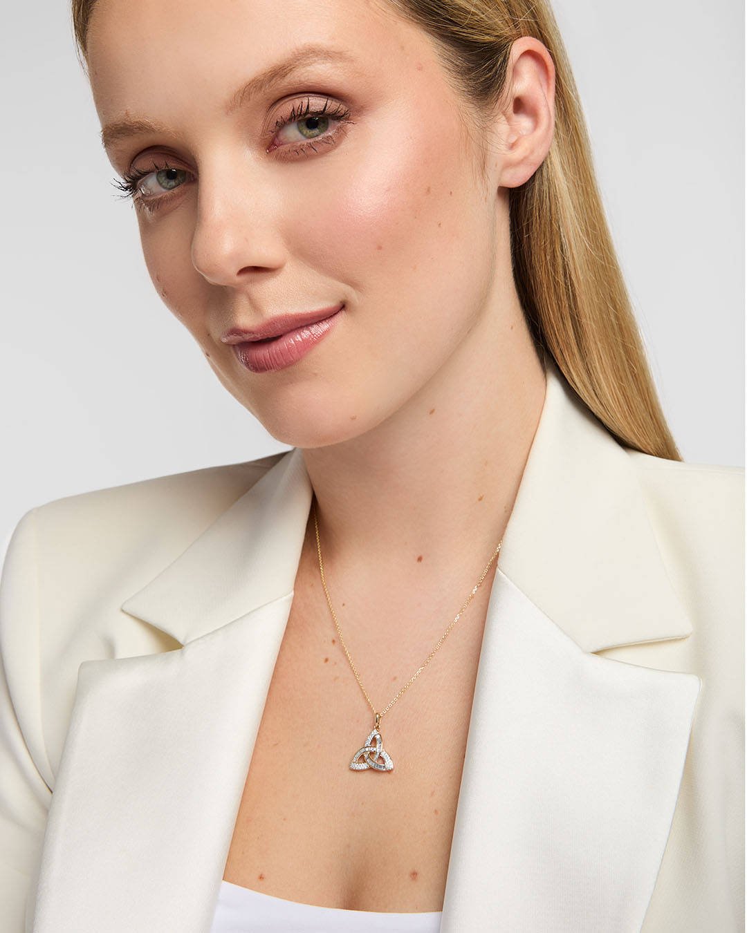 model wearing 14K gold Trinity Knot pendant with sparkling diamonds, symbolising eternal love and Irish heritage in an elegant design