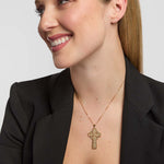 Woman showcasing a large yellow gold Celtic cross pendant necklace