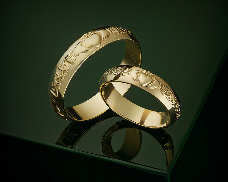 matching gold Claddagh wedding bands on the dark-green background