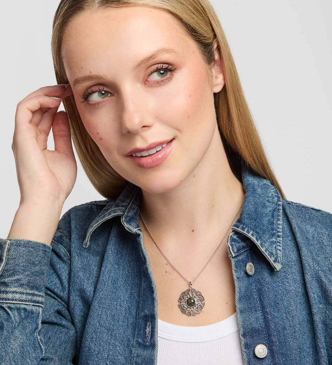 a model wearing Connemara marble and marcasite pendant with intricate open Celtic knotwork on a silver chain