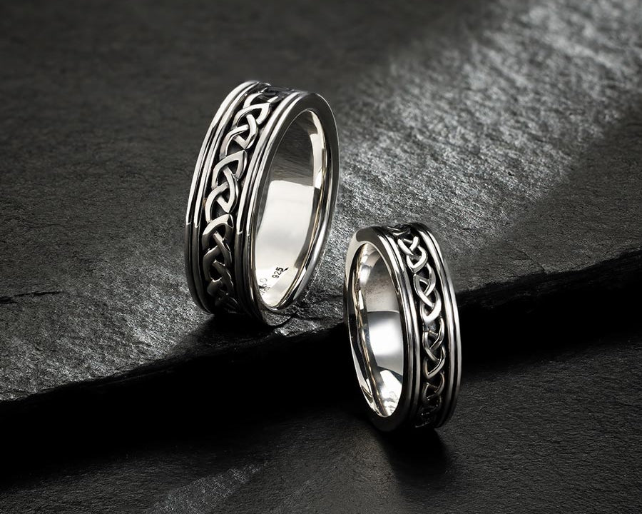 two set of mens celtic wedding bands on the dark stone background