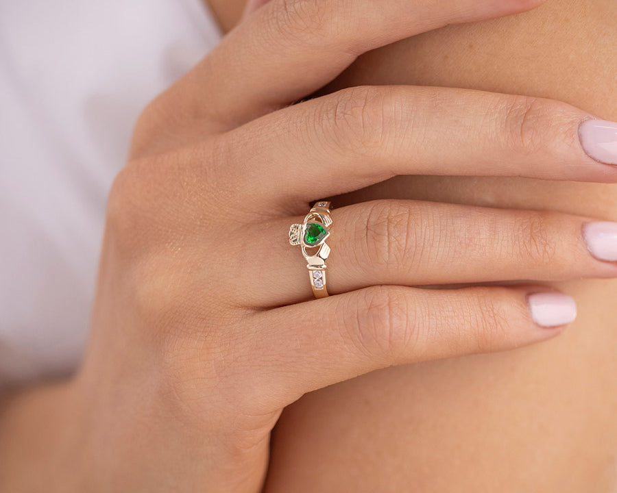 green stone claddagh ring presented on the female hand