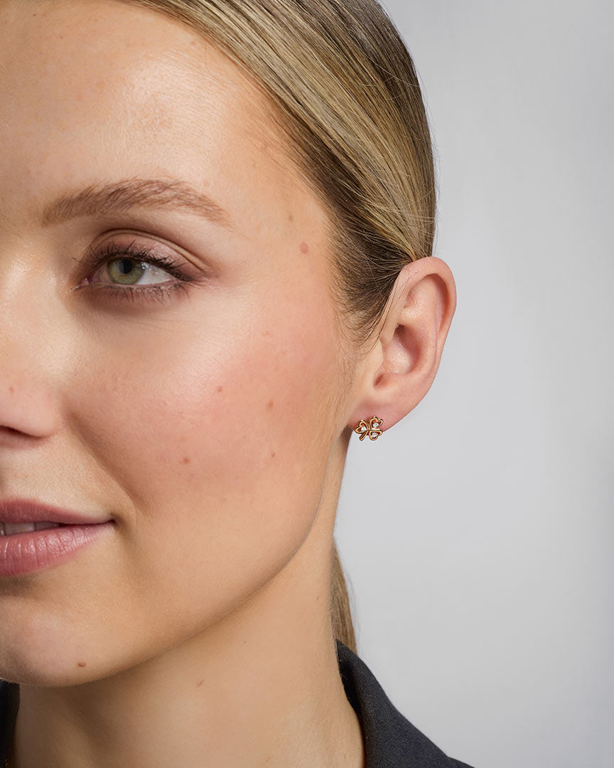 close-up image of a model wearing gold diamond shamrock earrings s33482 