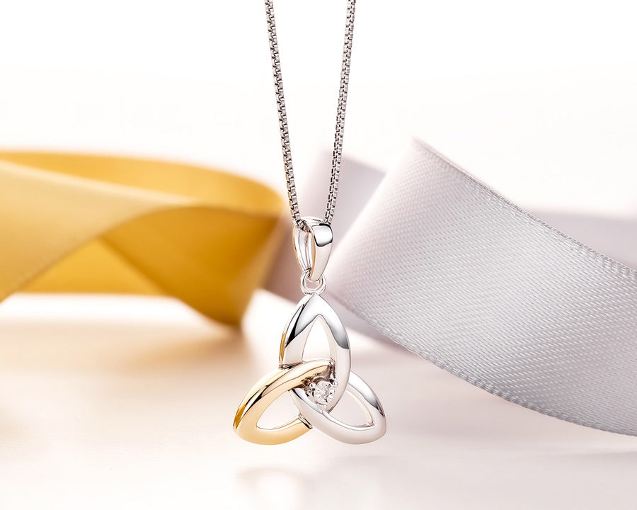 gold and silver Trinity Knot necklace styled with yellow and white ribbons