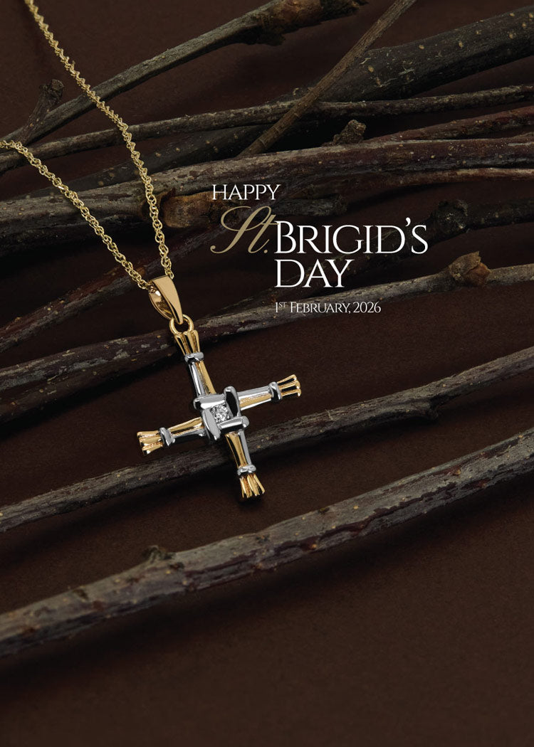 lifestyle image of st brigid's cross pendant on plant straws with happy st brigids day text - mobile version