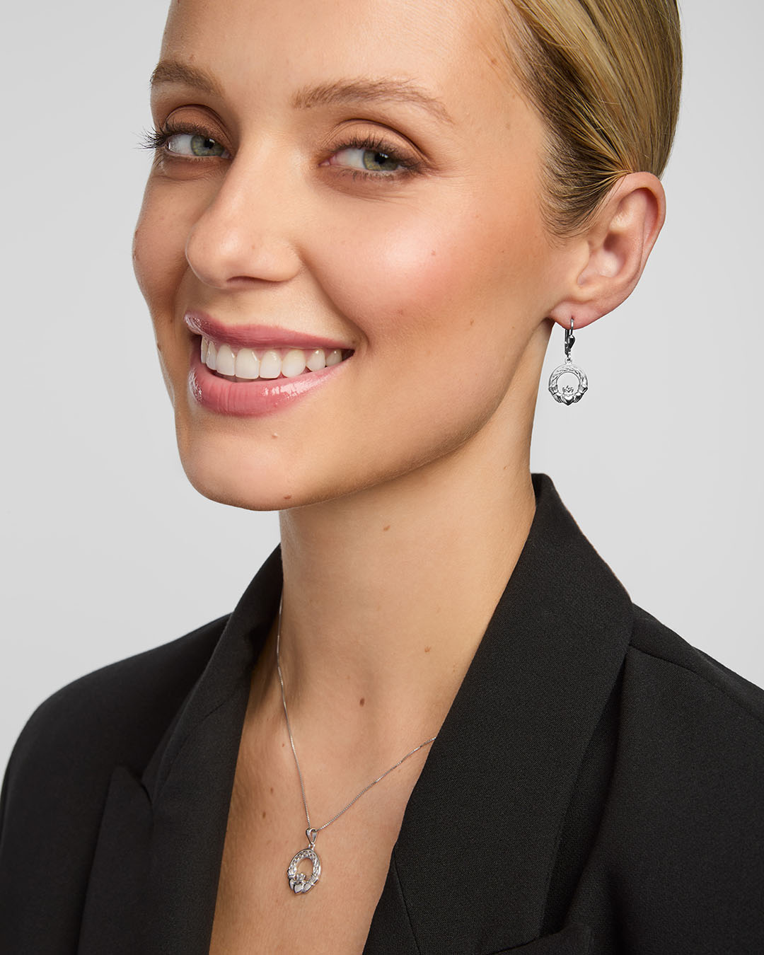 a female model wearing a matching Celtic Claddagh necklace and earrings set from Solvar