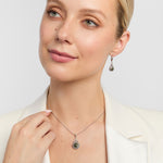model wearing celtic trinity knot earrings and pendant set with round connemara marble centre